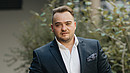 Matthäus Fandrejewski, Vorsitzender der dbb jugend, steht in einem begrünten Innenhof.