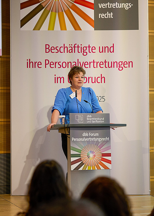 Eine Frau hält einen Vortrag an einem Rednerpult