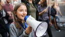 Ein Mädchen spricht auf einer Demonstration in ein Megafon