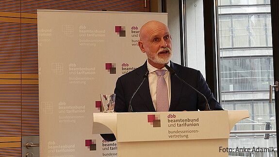 Zu sehen ist Volker Geyer, dbb Bundesvorsitzender der am Podium steht und zur dbb bundesseniorenvertretung spricht. 