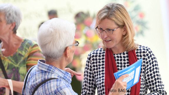 Das Foto zeigt eine Seniorin im Austausch mit einer anderen Frau.