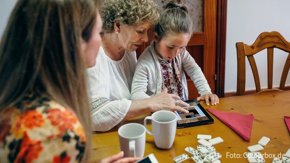 Frauen Junge Mutter, Großmutter und Enkeltochter sitzen an einem Tisch.