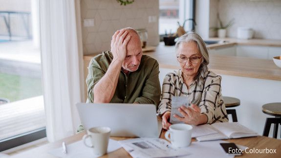Stressed senior couple calculate expenses or planning budget together at home.