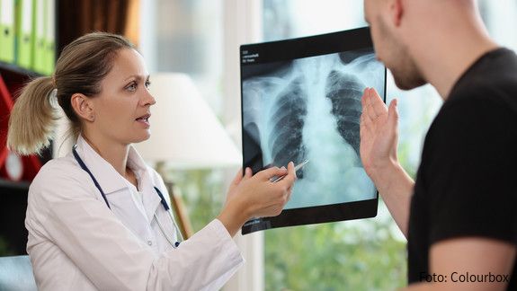 Family doctor shows x-ray picture to patient at appointment