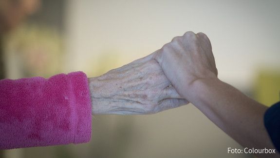 Die Hand eines jungen Menschen hält die Hand eines alten Menschen