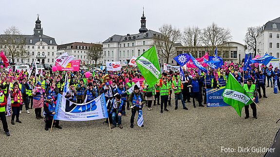 Eine Menschenmenge mit bunten Warnwesten und Fahnen auf dem Schlossplatz in Saarbrücken