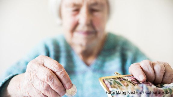 Altersarmut ist weiblich Eine unglücklich wirkende Seniorin zählt am Tisch die wenigen Münzen ihre Pension.