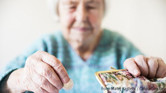 Altersarmut ist weiblich Eine unglücklich wirkende Seniorin zählt am Tisch die wenigen Münzen ihre Pension.