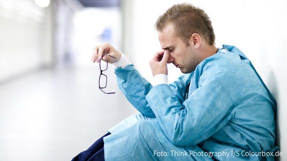 Personal des öffentlichen Gesundheitsdienstes Arzt sitzt erschöpft am Boden