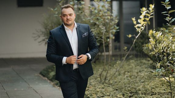 Matthäus Fandrejewski, Vorsitzender der dbb jugend, steht in einem begrünten Innenhof.