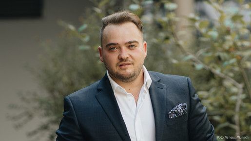 Matthäus Fandrejewski, Vorsitzender der dbb jugend, steht in einem begrünten Innenhof.