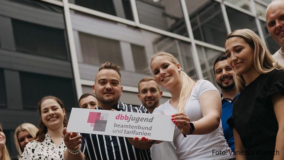 START-Broschüre - dbb jugend Zu sehen sind Mitglieder der dbb jugend mit einem Schild, auf dem "dbb jugend" steht.