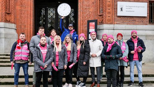 Das Foto zeigt Gewerkschaftsmitglieder auf Demos, die ihre Plakate präsentieren. 
