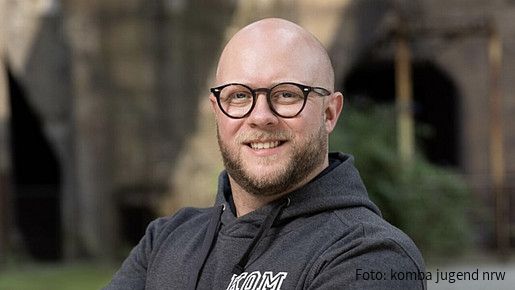 Foto zum Thema "Ausbildung zum Lebensmittelkontrolleur": Zu sehen ist Florian, der als Lebensmittelkontrolleur in Mönchengladbach arbeitet. Er trägt einen schwarzen Hoodie, seine Arme sind verschränkt.